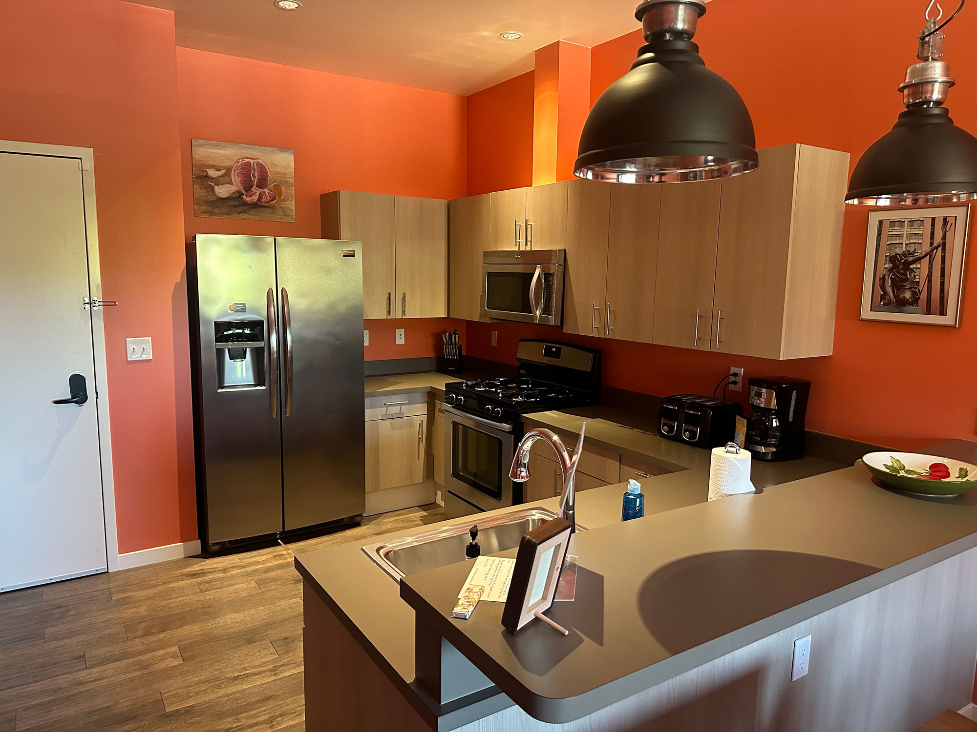 Chinook Suite 203 Kitchen with orange walls and art on the wall