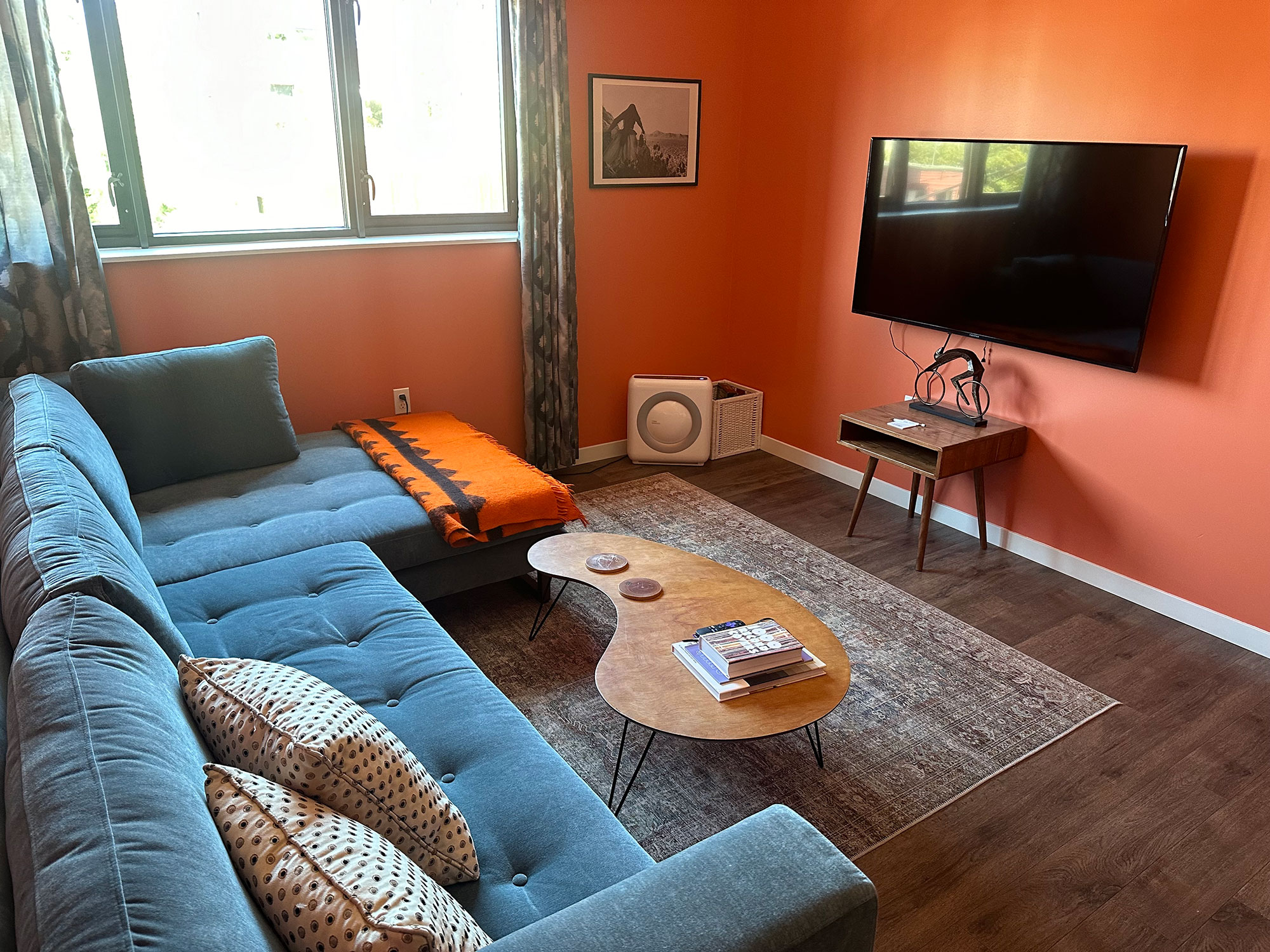 Chinook Suite 203 Living Room with orange walls, a tv on the wall, and furniture throughout